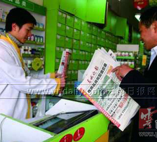 云南一心堂店内卖报纸