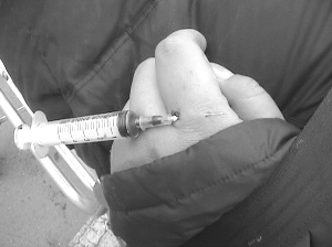 吸毒男子手扎注射器倒在街头