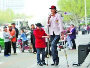 2米26小伙为筹医药费街头卖唱