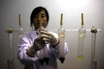 一名工作人员演示避孕套如何防止病毒的传播