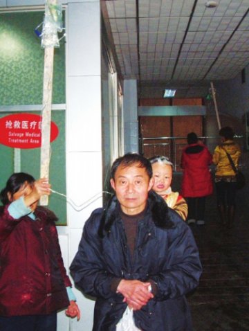 医院床位紧张 患者举棍站着输液
