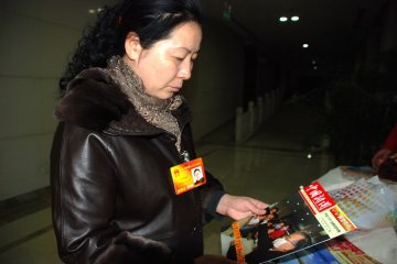 “两会”代表翻阅中国疾控中心编印的中国新闻2010年“两会”甲流防控和食品安全专辑