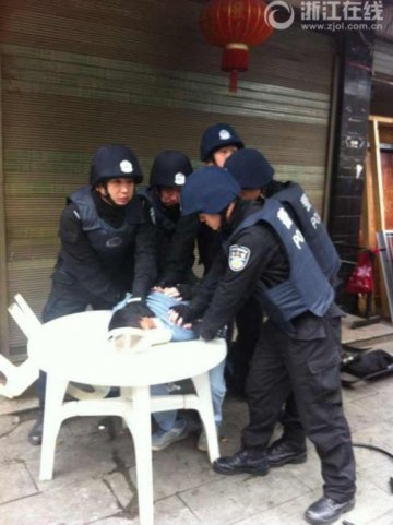 患艾滋逃犯身上出血街头发疯砸店 特警持钢叉制服