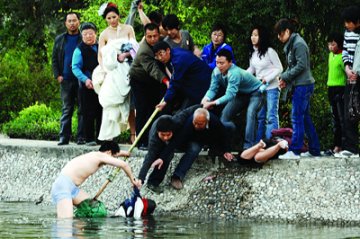 新人拍婚纱照时有人落水 新郎脱衣入湖救人