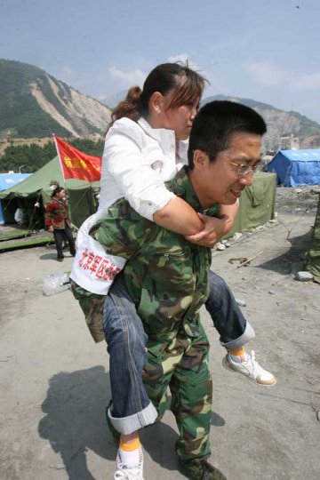 2008年5月23日上午，北京军区总医院医疗救援队队员正在将空转过来的轻伤员进行处理后送到灾民救助点等待统一转运到安全地带