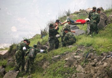 第三军医大学医疗队沿着陡峭的山坡艰难转运伤员