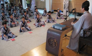 小学生穿汉服席地而坐读国学