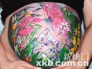 孕妇在肚皮上绘画后拍照当圣诞卡