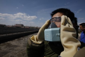 生物反应池旁戴着面罩的工人
